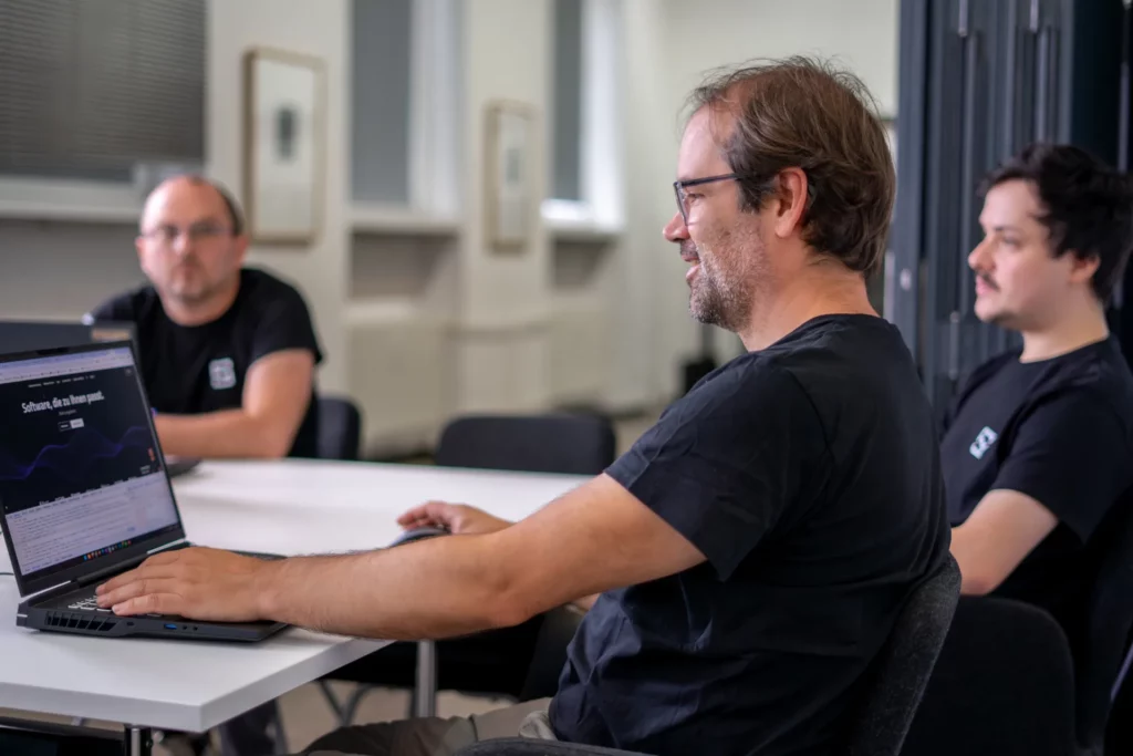 Gesch&auml;ftsf&uuml;hrung und Softwareentwickler im B&uuml;ro von SinusQuadrat &ndash; gemeinsames Teamfoto